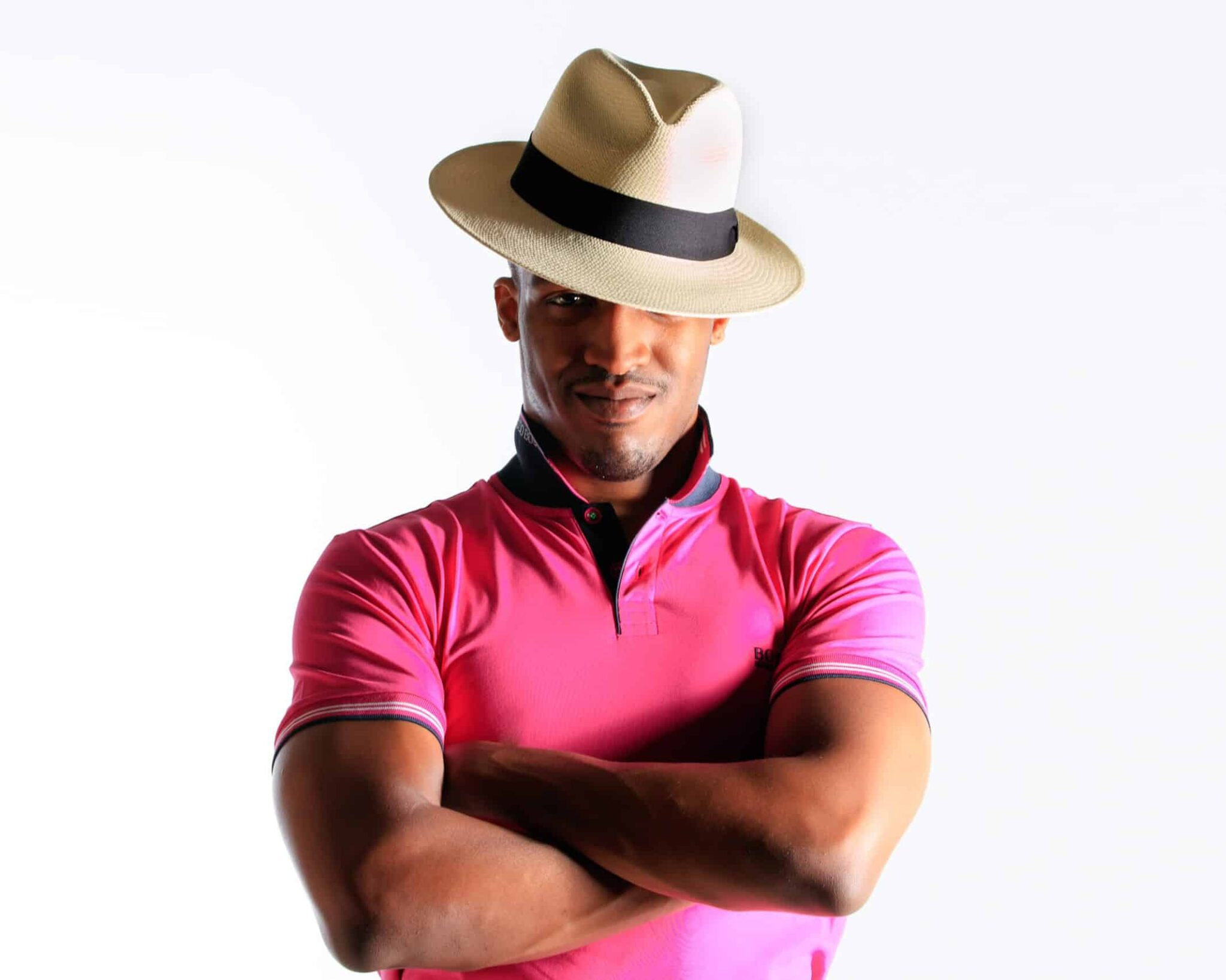 Man in pink shirt wearing a hat.