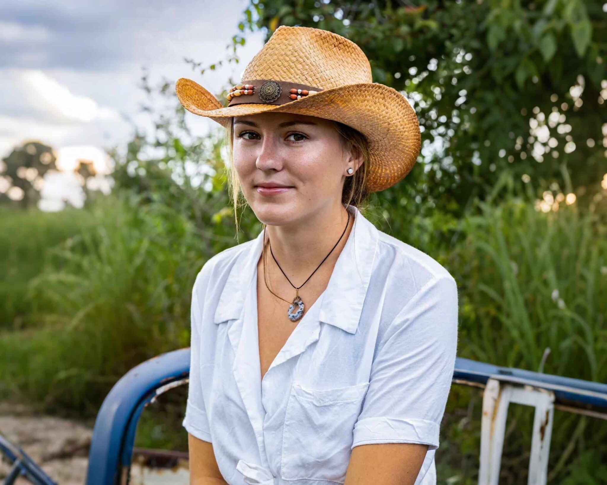 Young woman in cowboy hat outdoors.